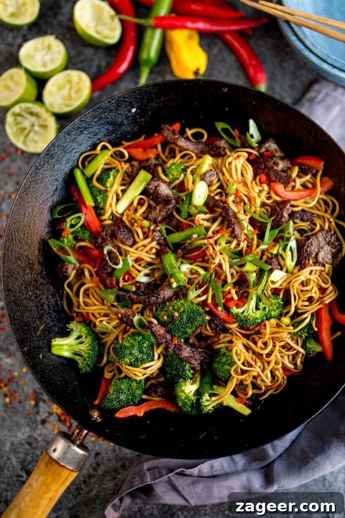 Crispy Chili Beef Noodles Recipe for Flavorful Weeknight Dinner 4 Overhead image of crispy chilli beef noodles with red pepper and broccoli in a wok.