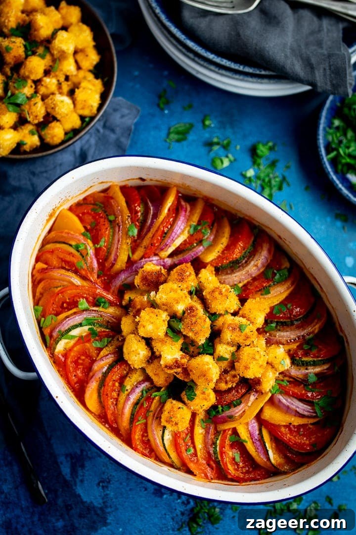 Ratatouille with Baked Feta Croutons: Simple Rustic Vegetable Bake 2 Overhead image of ratatouille in a white dish on blue background