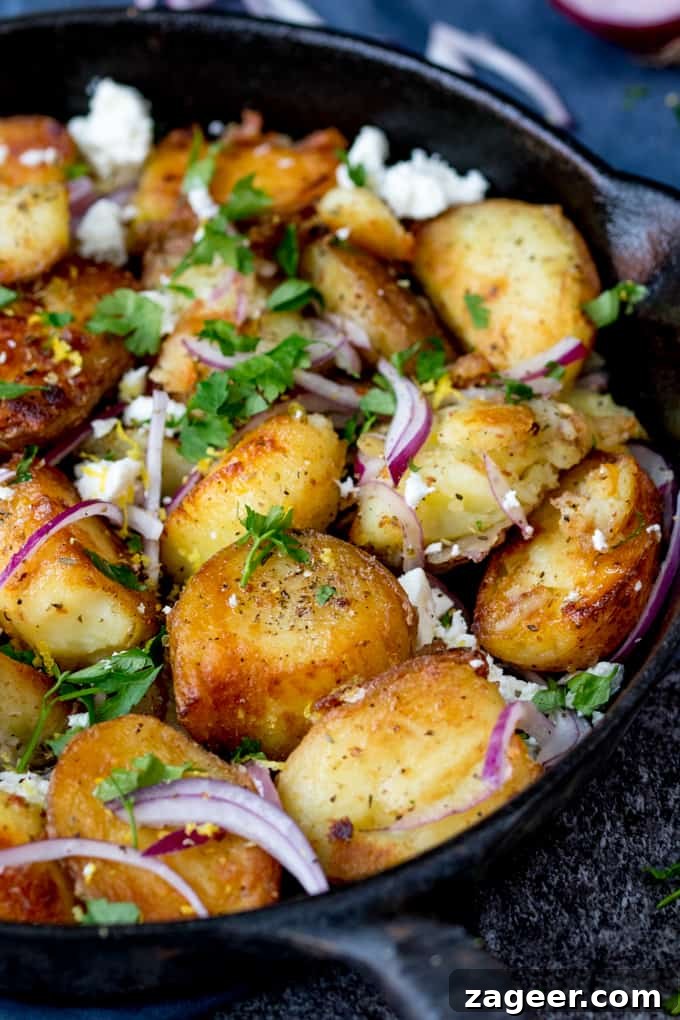 Greek-Style Potato Hash with Feta and Herbs 3 Close up shot of fried Greek potatoes with feta, red onion and parsley in a pan.