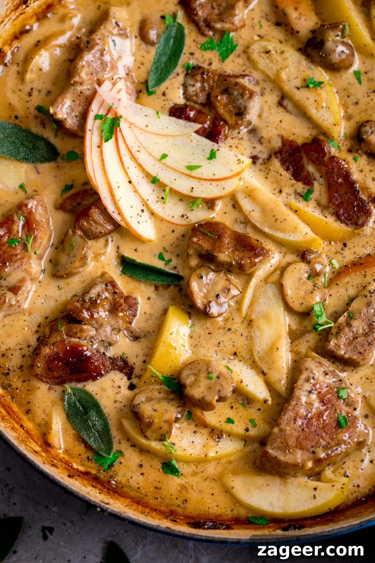 Creamy Pork and Apple Casserole Recipe with Herbed Crust 2 Close up overhead shot of creamy pork and apple casserole in a casserole dish.