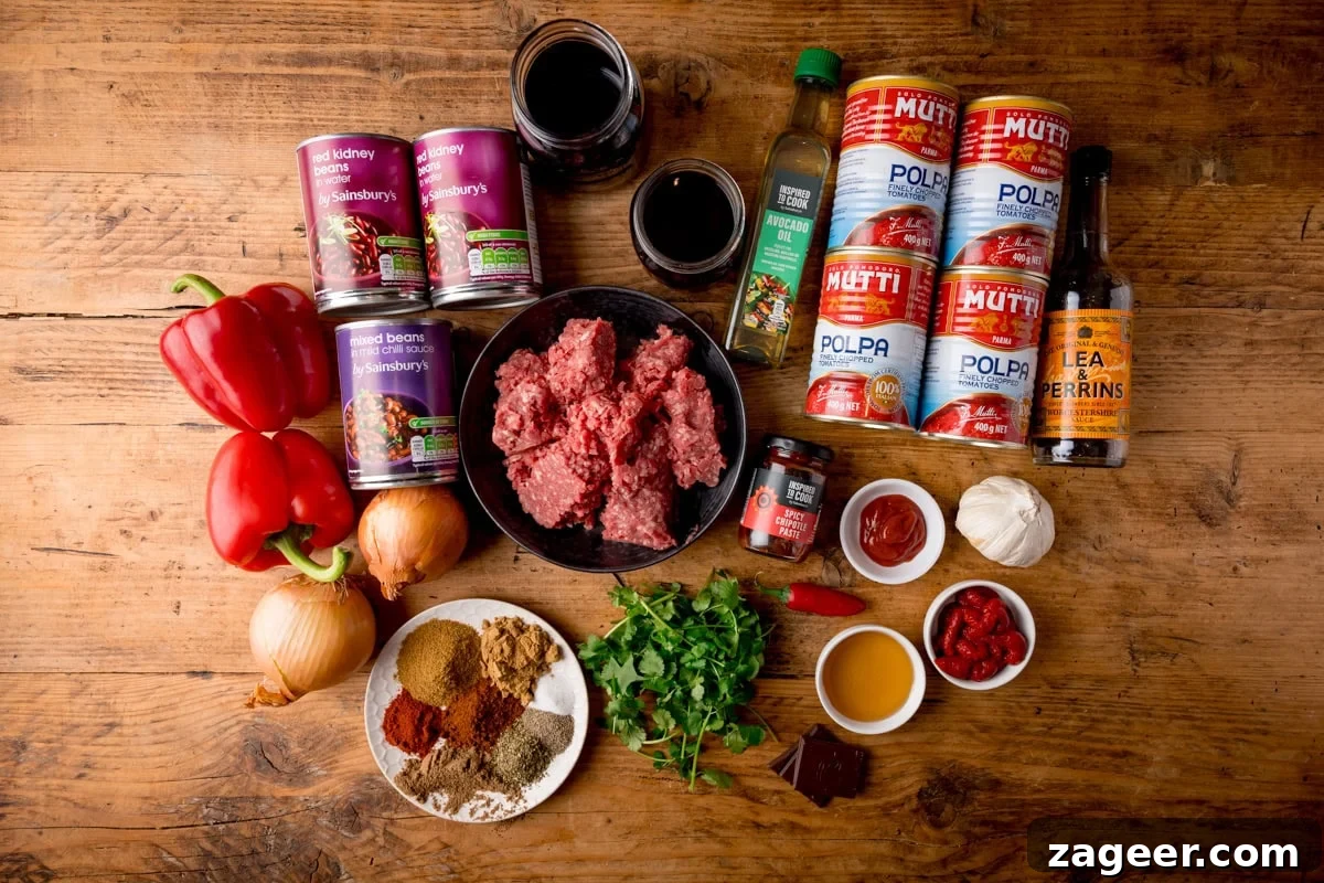 Authentic Chilli Con Carne Recipe with Smoky Beef and Beans 3 Individual ingredients for making a chili con carne laid out on a wooden table.