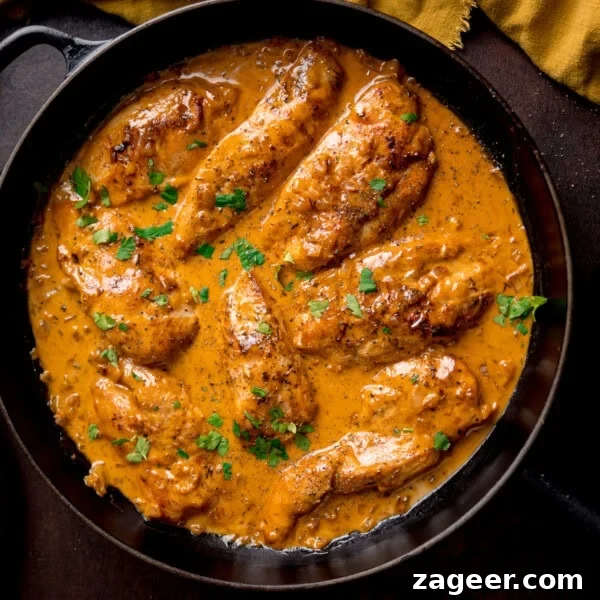 Creamy Baked Chicken with Potatoes and Herbed Sauce 6 Creamy honey mustard chicken topped with chopped parsley in a black frying pan.