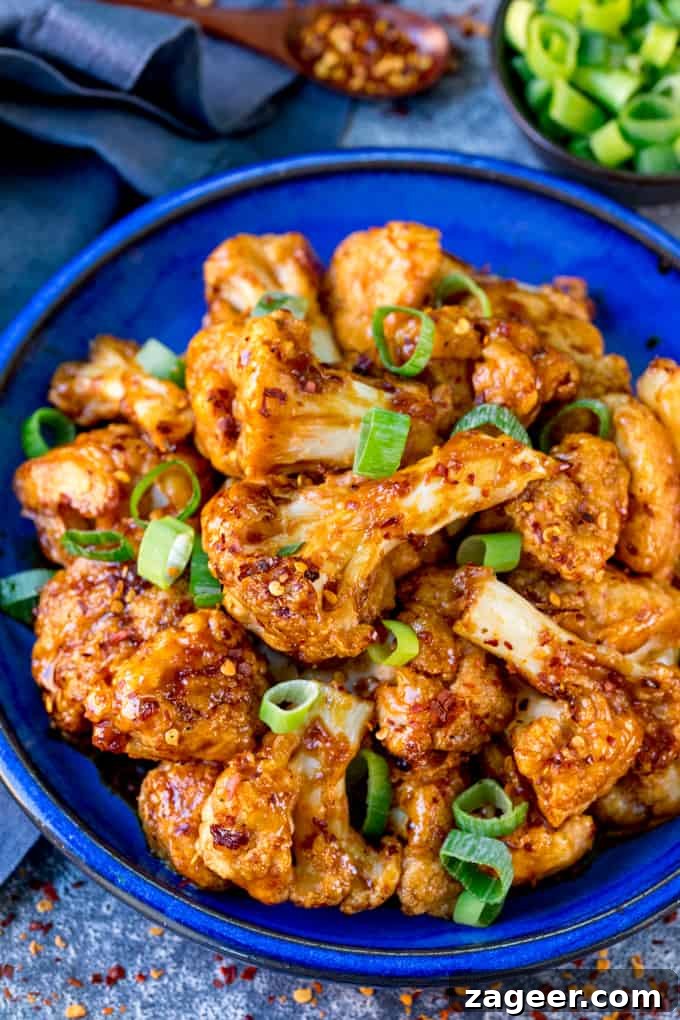 Asian-Style Baked Cauliflower Wings: Sticky Sesame Chili Recipe 2 Close up image of Asian cauliflower wings on a blue plate