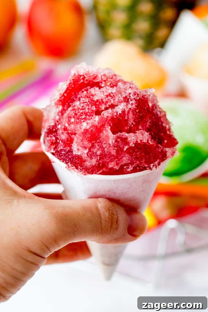 Close up of hand holding cherry flavoured snow cone