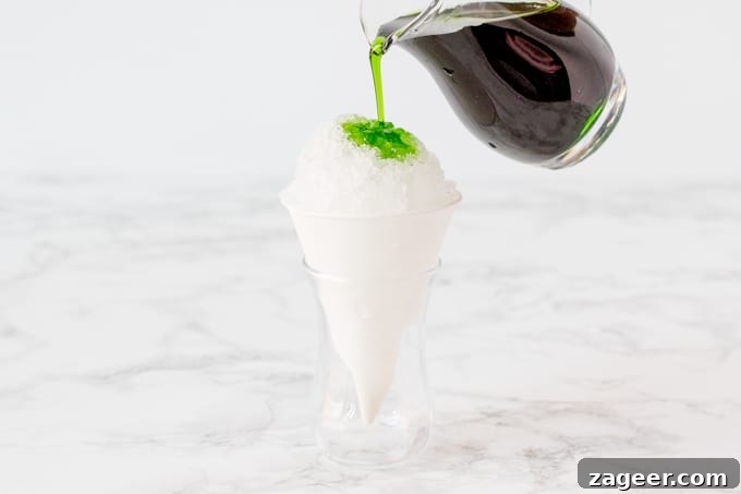 Pouring green apple syrup onto a cone of shaved ice