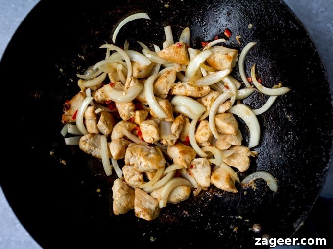 Honey-Soy Chicken Stir-Fry with Spicy Asian Noodles 4 Chicken and onions frying in a wok
