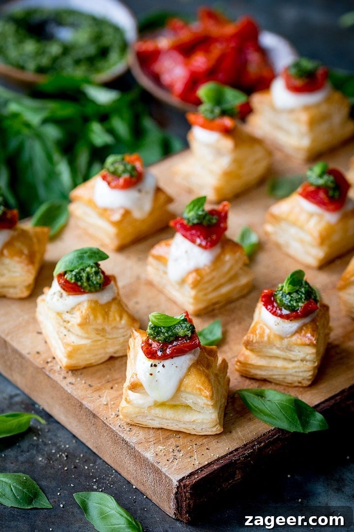 Caprese Puff Pastry Bites: Tomato, Basil & Mozzarella Appetizers 8 Puff pastry caprese bites - with mozzarella, pesto and sundried tomato - on a serving board