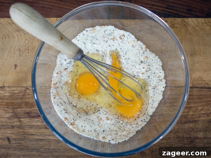 Gluten-Free Hazelnut Chia Pancakes with Blueberry Compote 4 Dry ingredients for chia hazelnut pancakes in a bowl with two eggs