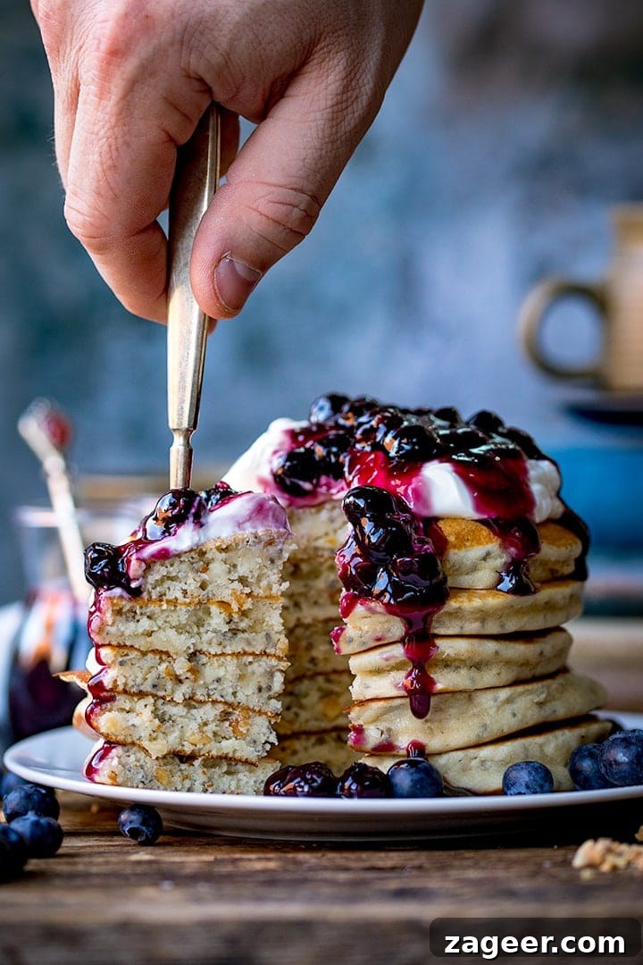 Gluten-Free Hazelnut Chia Pancakes with Blueberry Compote 7 Stack of chia hazelnut pancakes with a forkful being taken
