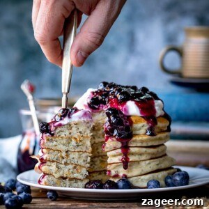 Forkful of Chia hazelnut pancakes with blueberry compote being taken