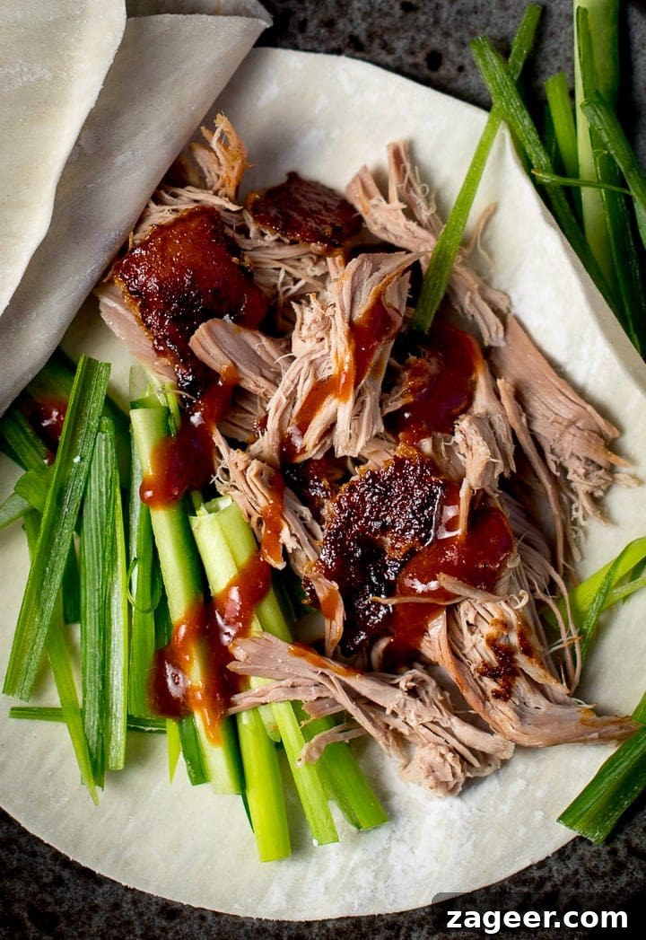 Crispy Homemade Roast Duck Recipe for Perfectly Crunchy Skin 9 close up of shredded duck and plum sauce on a chinese pancake