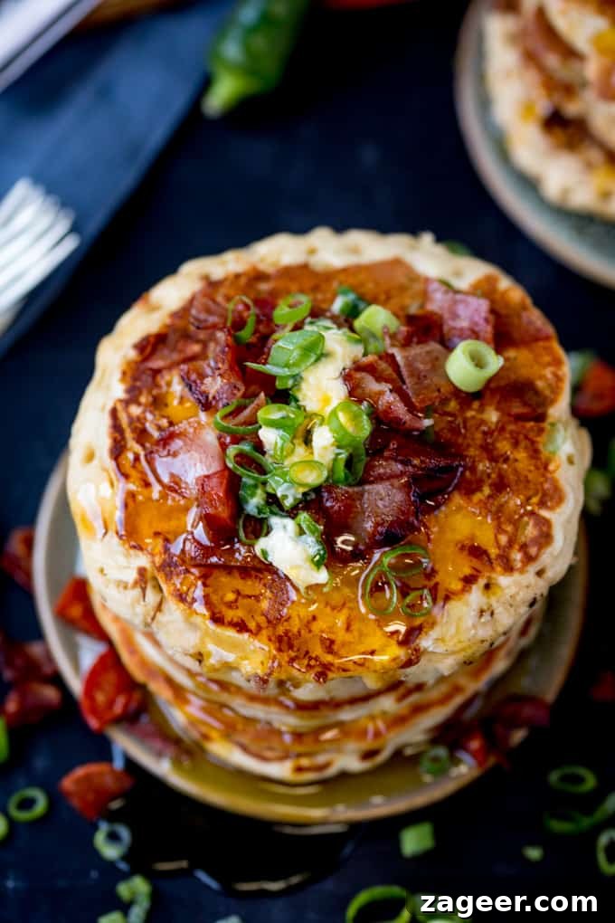 Savory Dinner Pancakes with Spicy Chilli Butter 3 Overhead image of a stack of savoury pancakes with bacon, spring onions and chilli butter on a dark background