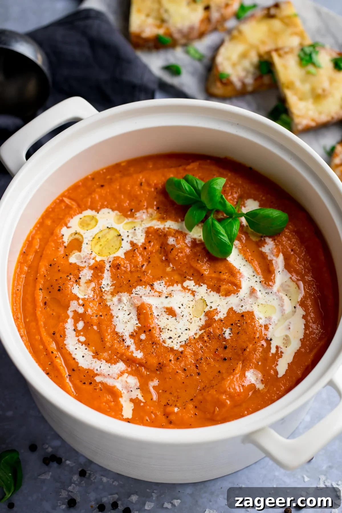 Homemade Creamy Tomato Soup Recipe from Scratch 5 A pot of delicious tomato soup topped with double cream; and a plate of cheese toast on the side.