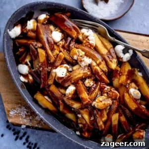Poutine in a grey dish on a wooden board