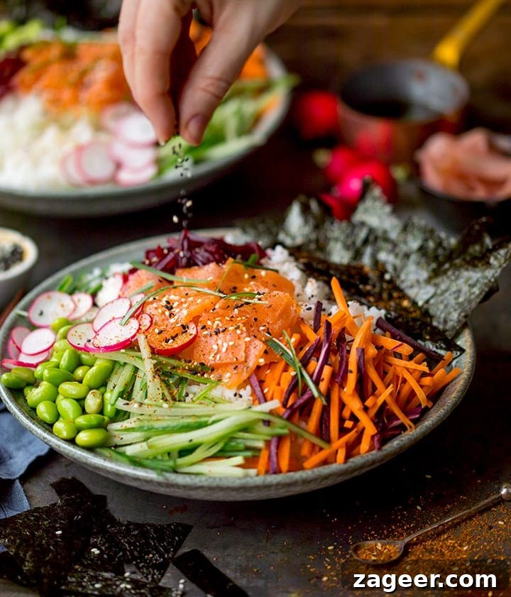 Salmon Sushi Bowl Recipe: Homemade Poke-Style Salmon Bowl 6 Sprinkling sesame seeds on a sushi salad bowl