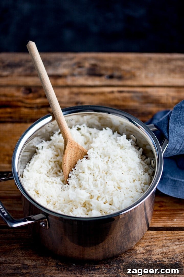 Perfectly Cooked Rice: Step-by-Step Guide for Fluffy Grains 2 Boiled rice in a pan with a wooden spoon in pan