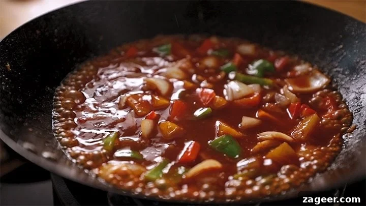 Authentic Sweet and Sour Chicken Recipe for Sticky, Tangy Sauce 6 Sweet and sour sauce with vegetables bubbling in a wok