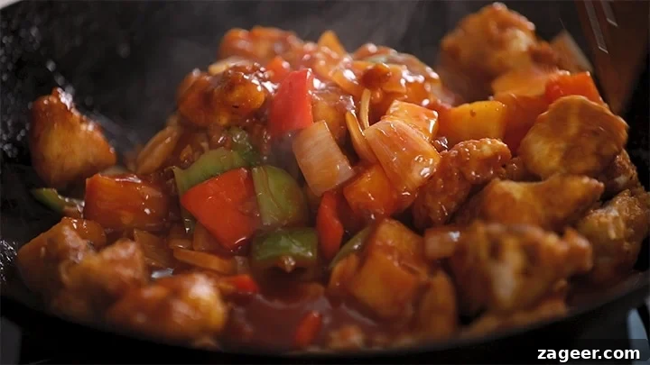 Authentic Sweet and Sour Chicken Recipe for Sticky, Tangy Sauce 7 Close up image of sweet and sour chicken in a wok