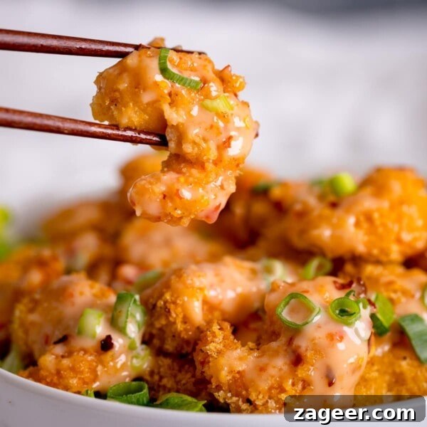 Mini Chicken and Bean Burritos with Zesty Salsa Recipe 10 Crispy shrimp being lifted out of a bowl with chopsticks. Shrimp is covered with bang bang sauce.
