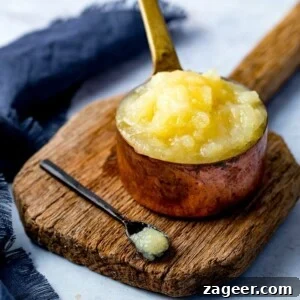 Homemade Applesauce from Scratch: Simple, Flavorful Recipe 7 Apple sauce in a copper pan on a wooden board against a light background
