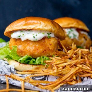 Crispy Fish Sandwich with Shoestring Fries Recipe 5 Breaded haddock burger on brioche bun with lettuce and chive-speckled mayonnaise. Shoestring fries to the right of the burger. A second burger in background.