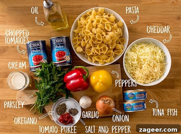 Cheesy Tomato and Tuna Pasta Bake Recipe 4 Ingredients for Tuna Tomato Pasta Bake on a wooden table. Each ingredient is labelled.