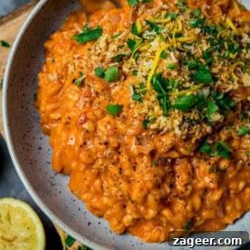 Pantry-Friendly Recipes: Delicious Meals from Store Cupboard Staples 11 A plate of creamy tomato risotto topped with chopped parsley, lemon zest, crispy breadcrumbs