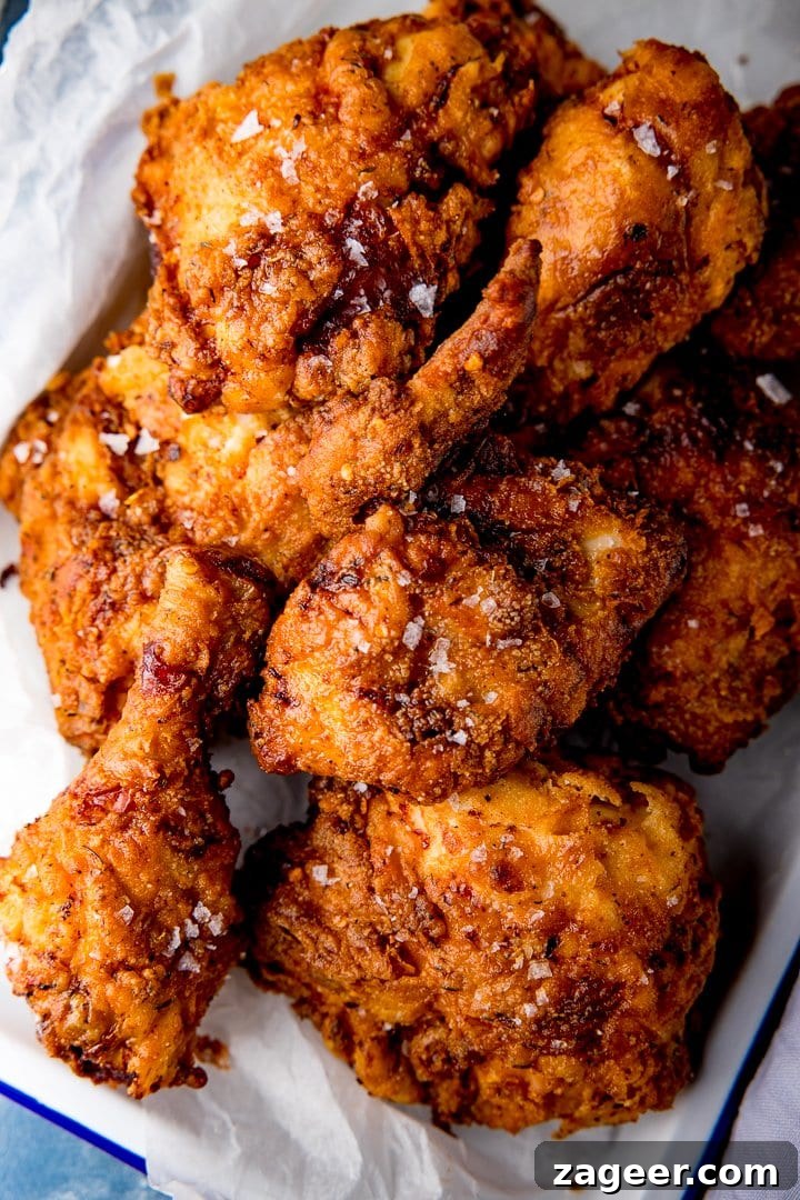 Crispy Fried Chicken Recipe for Perfectly Crunchy Skin 2 Overhead of crispy fried chicken pieces with a sprinkling of salt