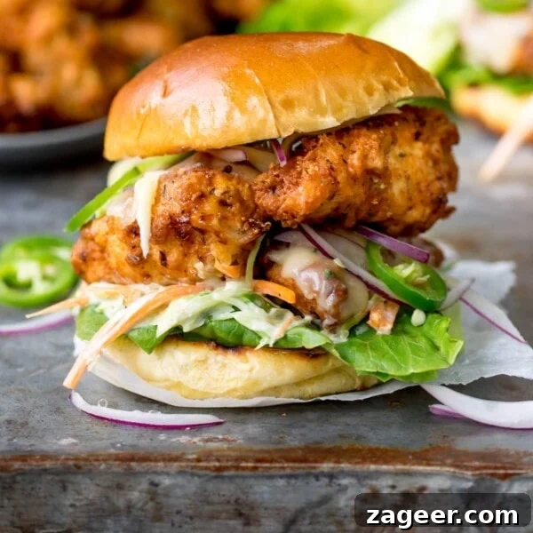 Crispy Fried Chicken Recipe for Perfectly Crunchy Skin 11 Square image of Crispy chicken burger on a brioche bun with lettuce.