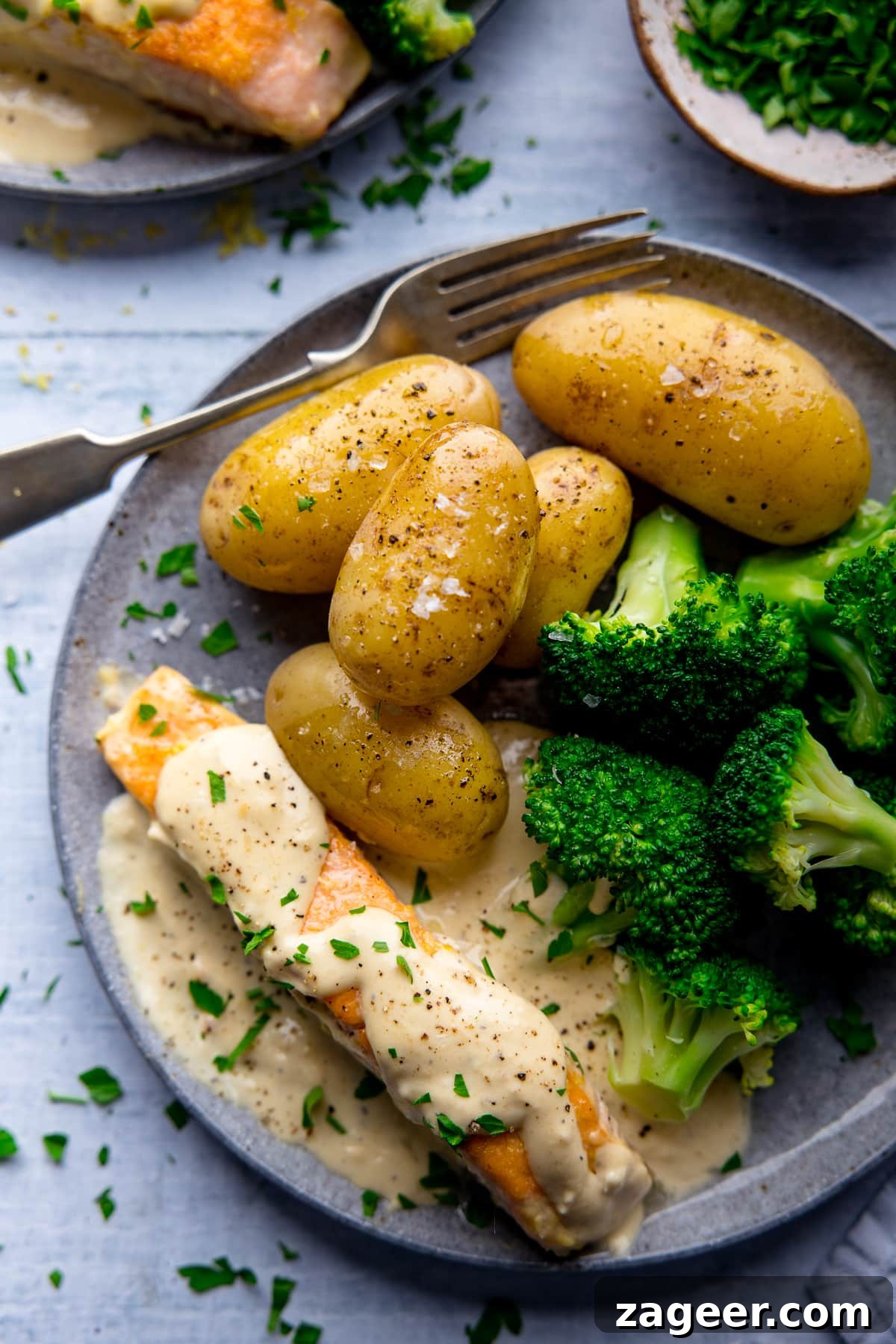 Creamy White Wine Salmon Recipe with Garlic and Herbs 6 Salmon in cream sauce, broccoli and potatoes on a grey plate