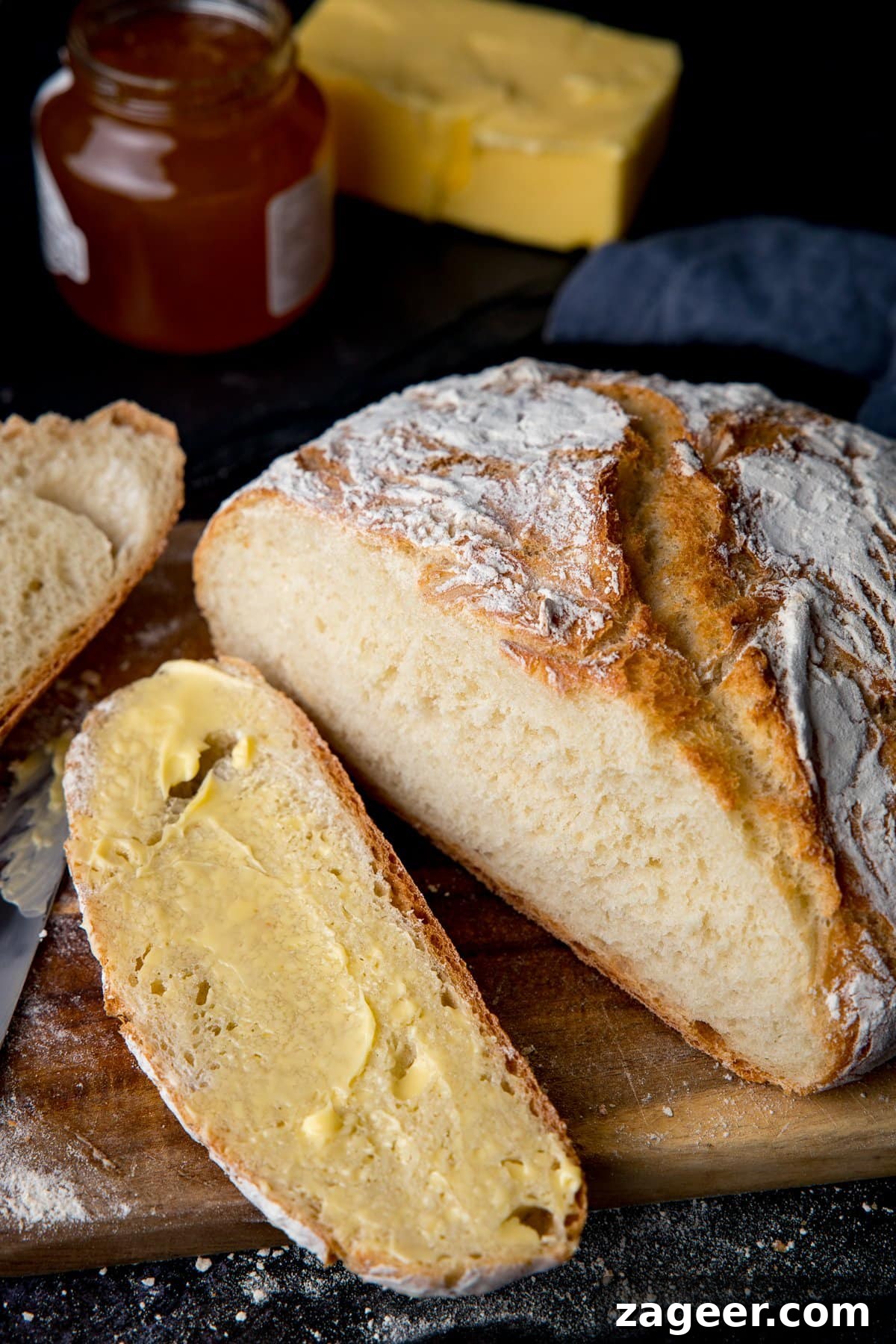 Authentic Artisan Bread Recipe: Simple Sourdough & Crusty Loaf Guide 6 Homemade artisan bread slice open and slice spread with butter