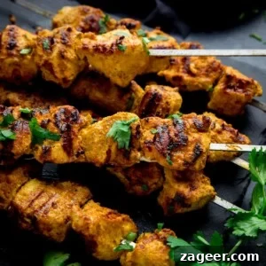 chicken tikka skewers on a dark background
