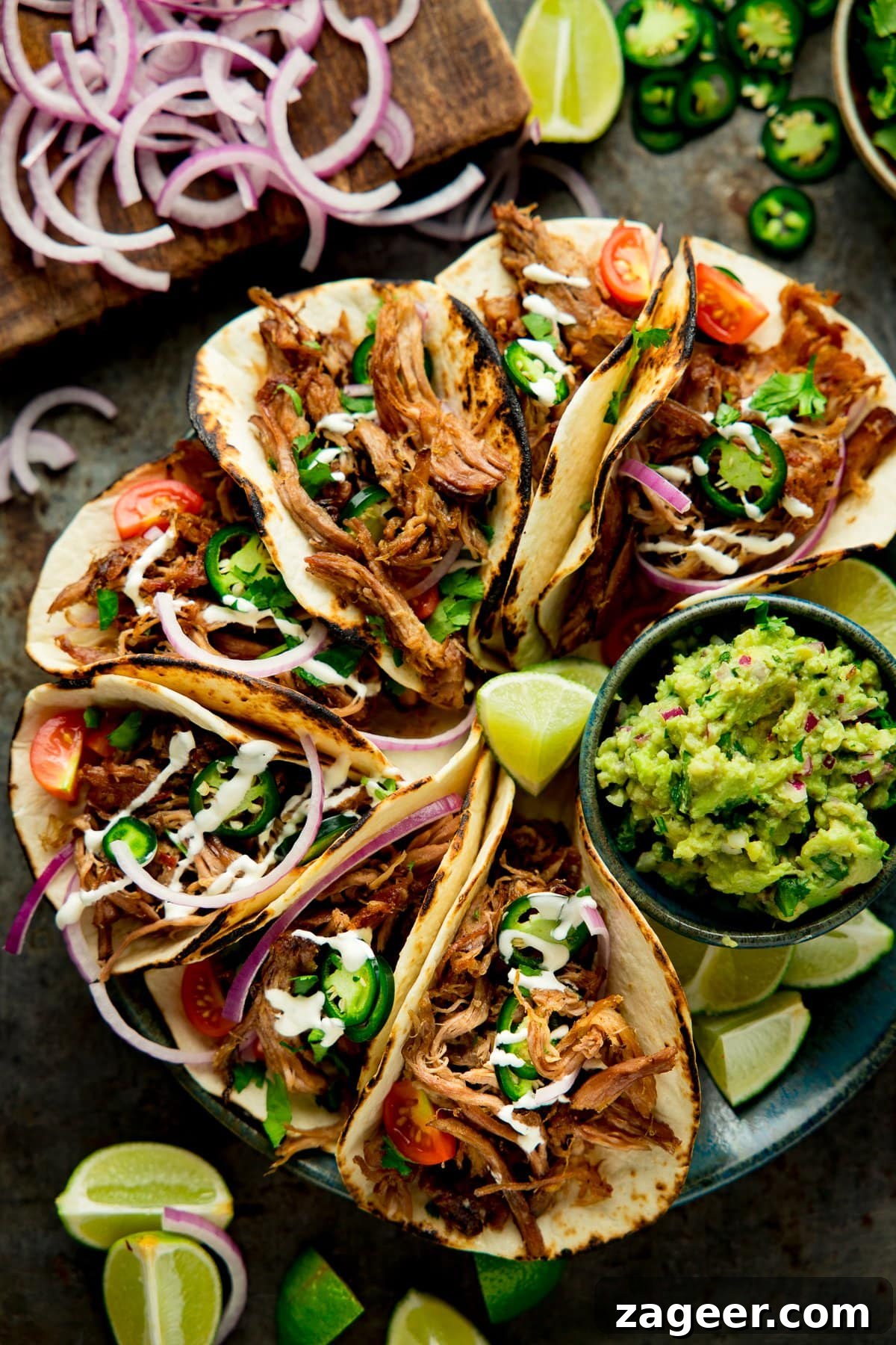 Authentic Lamb Barbacoa Recipe — Slow-Cooked Mexican-Style Lamb 2 Overhead shot of Lamb Barbacoa Carnitas Tacos on a plate with a bowl of guacamole
