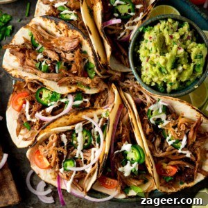 Authentic Lamb Barbacoa Recipe — Slow-Cooked Mexican-Style Lamb 15 Square image of a plate of Lamb Barbacoa Carnita Tacos with a bowl of guacamole