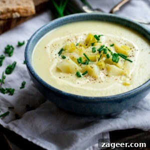 Creamy Leek and Potato Soup Recipe with Fresh Herbs 14 leek and potato soup in a blue bowl, topped with potatoes and chives