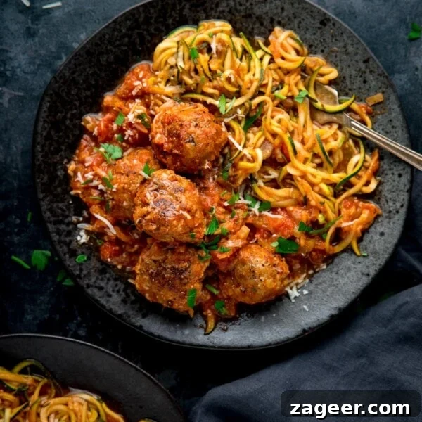 Authentic Swedish Meatball Recipe with Creamy Gravy and Lingonberry 10 Square image of Turkey meatballs and courgetti on a dark plate