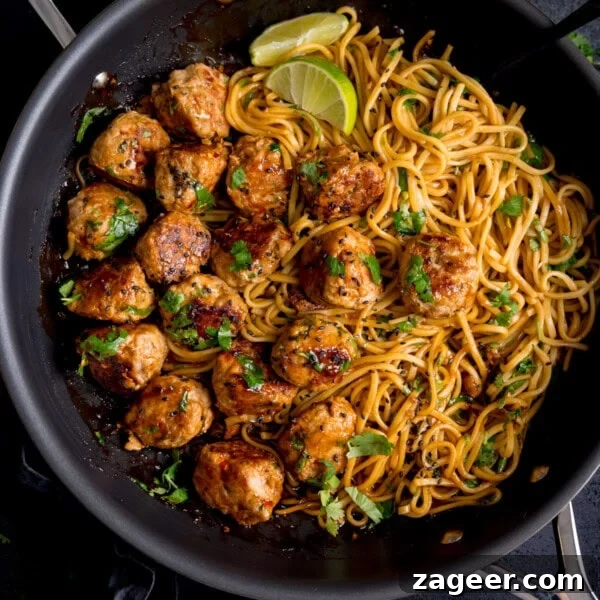 Authentic Swedish Meatball Recipe with Creamy Gravy and Lingonberry 11 A frying pan containing cooked noodles and browned lemongrass meatballs