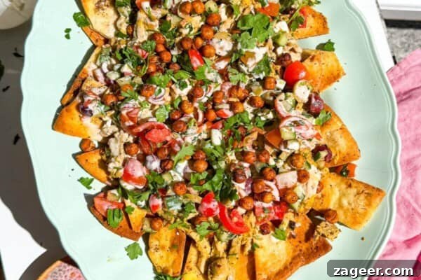 Mediterranean Ground Beef and Rice Bowls with Feta & Herbs 16 Hand holding platter of Greek pita nachos.