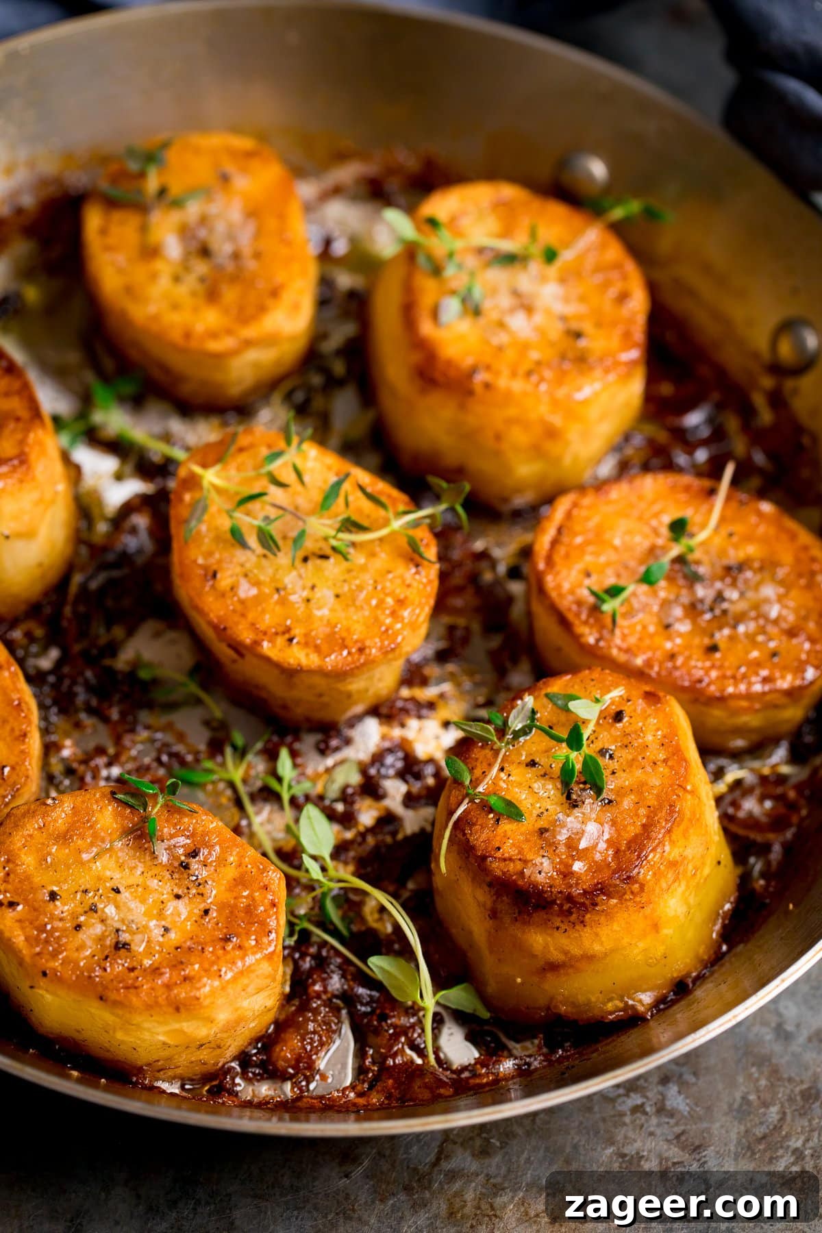 Perfectly Crispy Fondant Potatoes: Classic Oven-Roasted Recipe 8 fondant potatoes in a pan topped with thyme and salt
