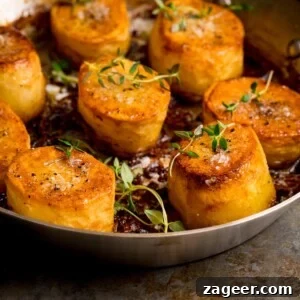 Perfectly Crispy Fondant Potatoes: Classic Oven-Roasted Recipe 9 Square image of fondant potatoes in a frying pan, topped with fresh thyme and salt