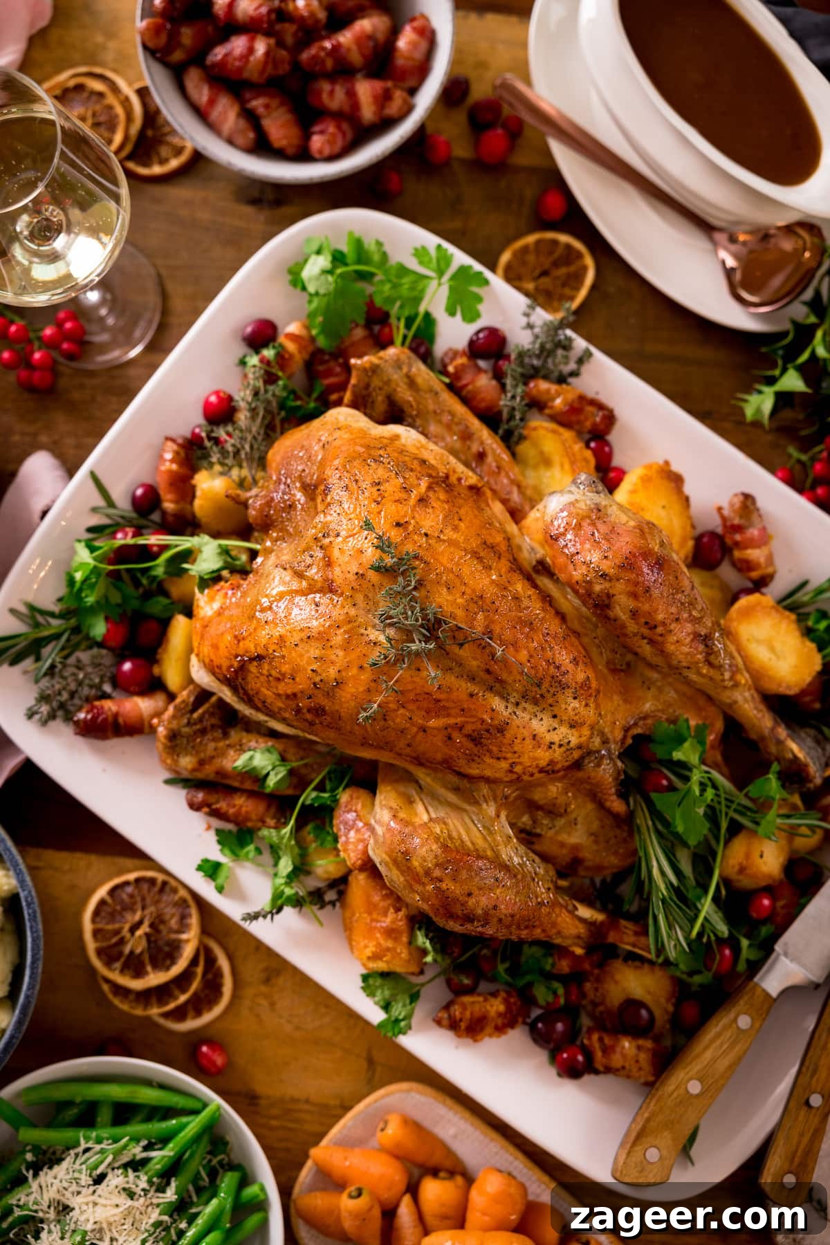 Roast turkey on a white rectangular plate surrounded by side dishes.