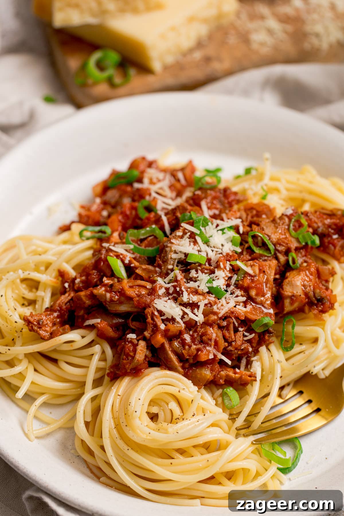 Turkey Bolognese from Leftover Roast: Quick Family Dinner 2 leftover turkey bolognese on a white plate with spaghetti. Topped with spring onions.