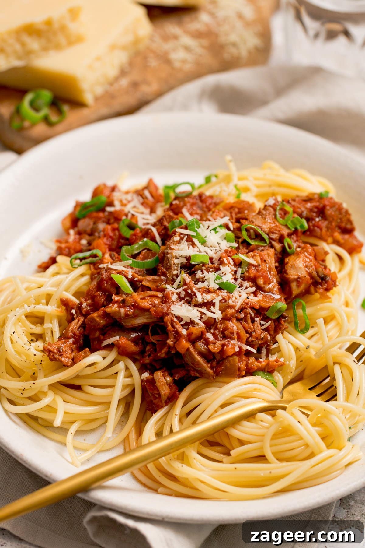 Turkey Bolognese from Leftover Roast: Quick Family Dinner 5 leftover turkey bolognese on a white plate. Gold fork resting on the plate.