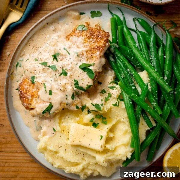 Classic Hungarian Chicken Paprikash Recipe — Creamy Paprika Chicken 14 A plate with garlic parmesan chicken in creamy sauce
