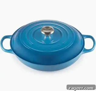 Classic Hungarian Chicken Paprikash Recipe — Creamy Paprika Chicken 15 A blue cast iron Le Creuset braiser with a lid and two handles, ideal for making one-pot chicken pasta.
