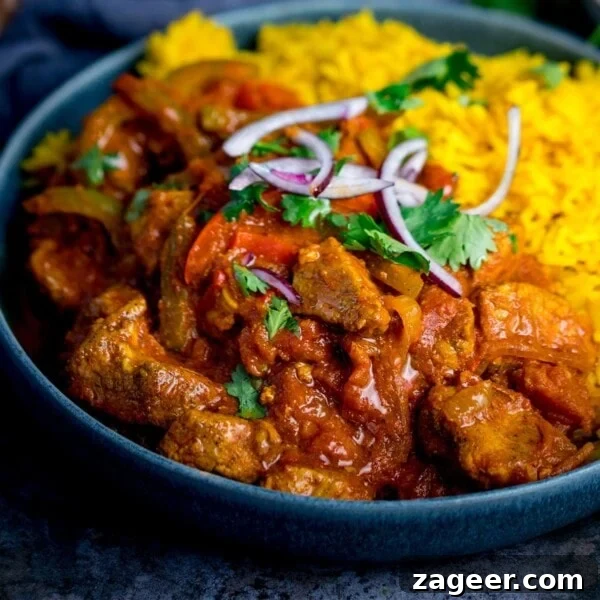 Creamy Chicken Pasanda Recipe: Aromatic Mughlai Curry Guide 16 Close up image of chicken Jalfrezi with pilau rice in a blue bowl