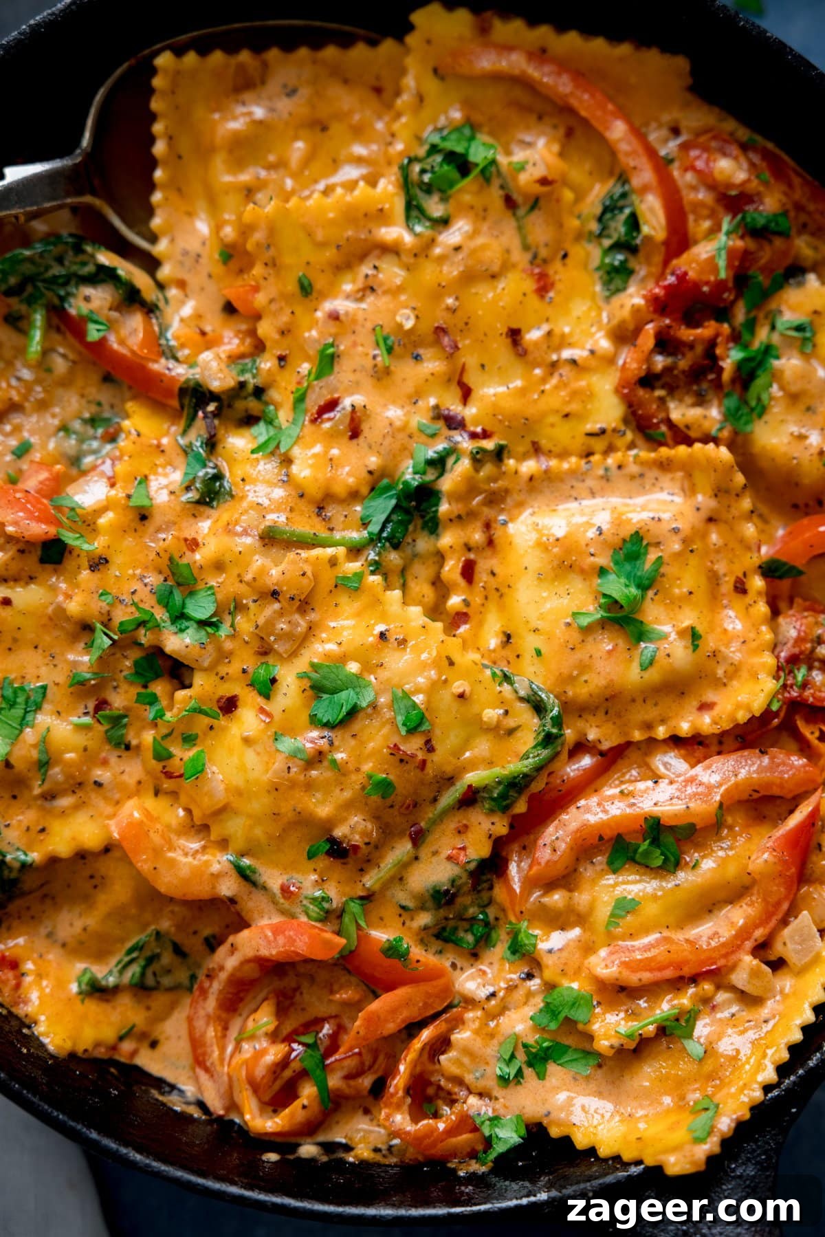 Creamy Tomato Sauce for Ravioli: Quick Weeknight Recipe 2 Close up overhead shot of ravioli in cream tomato sauce in a dark pan.