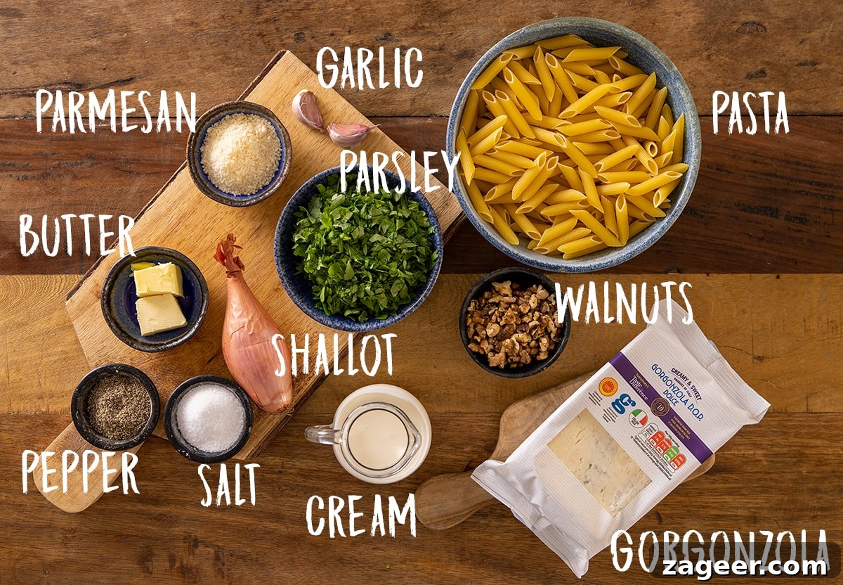 Creamy Gorgonzola Pasta with Garlic and Walnut Crumble 4 Labelled ingredients for making gorgonzola pasta on a wooden board.