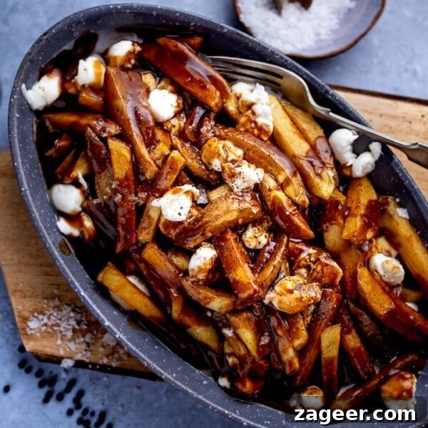 Authentic Lamb Kofta Recipe with Tangy Yogurt Sauce 12 Poutine in a grey dish on a wooden board