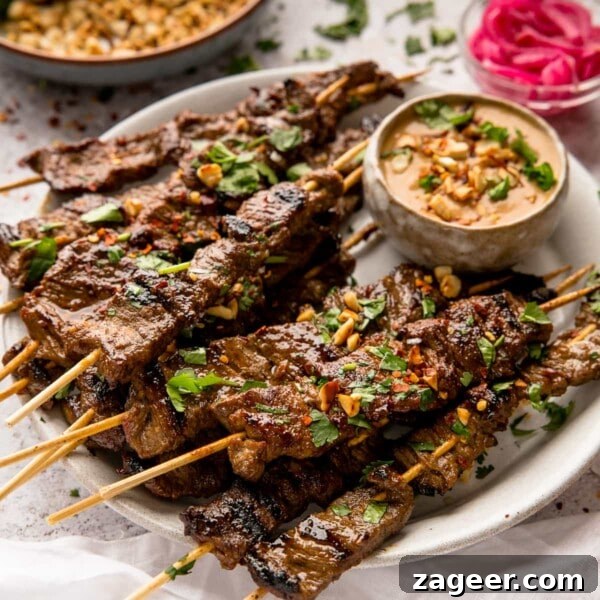 Authentic Lamb Kofta Recipe with Tangy Yogurt Sauce 13 beef satay on wooden skewers on a white plate